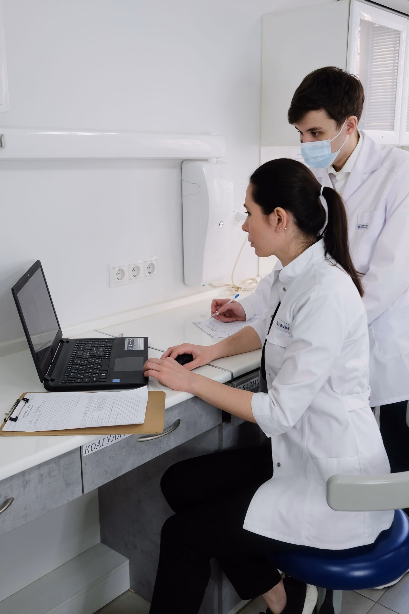 Healthcare professionals working together at a laptop.